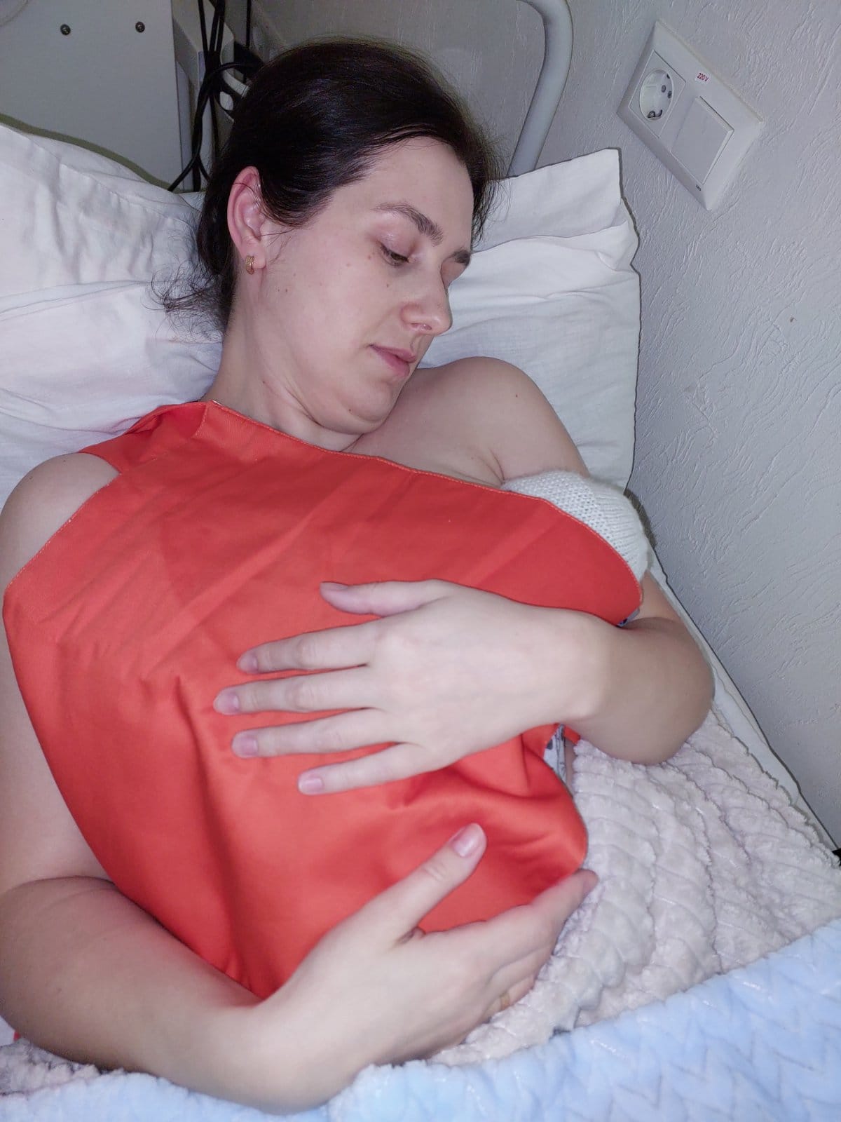 Ukrainian mother holding her baby skin-to-skin in a Kangaroo Mother Care wrap